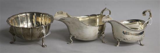 Two silver sauce boats and a fluted silver sugar bowl